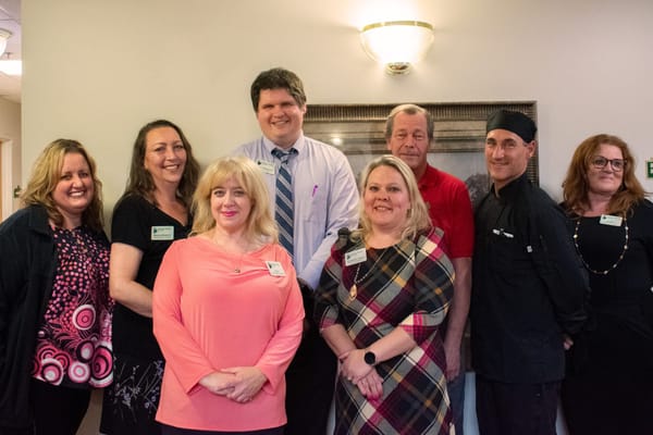 Staff members posing together in the facility lobby