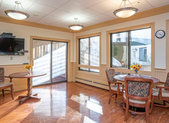 Bright common area with dining tables and windows