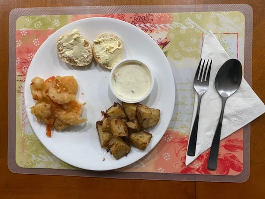 A meal served on a plate with shrimp and potatoes