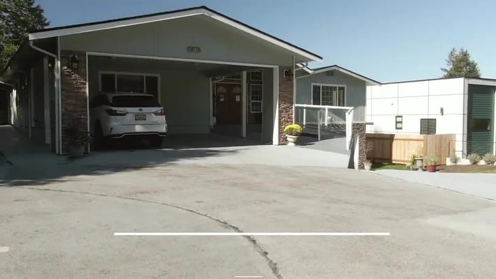 Exterior view of Elroi Adult Family Home with driveway and car