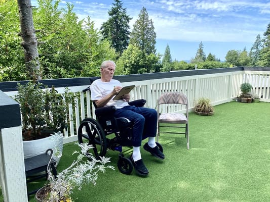 Senior man relaxing on a balcony with greenery