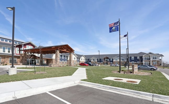 Exterior view of Colonial Village Overland Park with flags