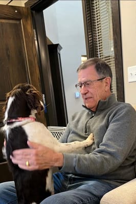 Senior resident interacting with a dog in a cozy room