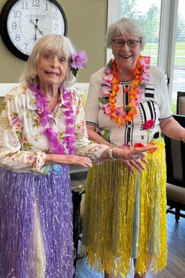 Residents enjoying a themed event with leis and smiles