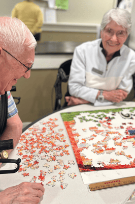 Residents engaging in a puzzle activity at a table