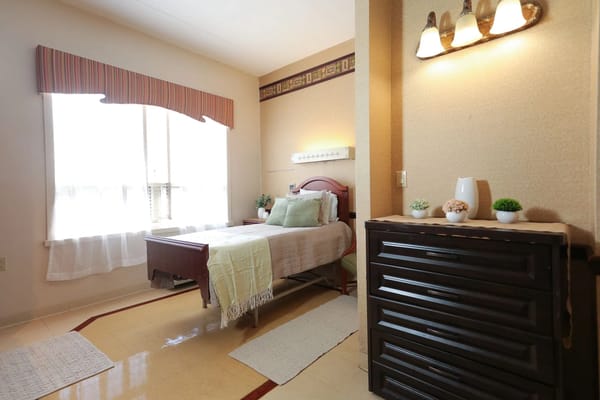 Cozy resident room with bed and dresser