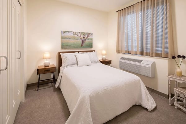 Bright and cozy bedroom with a bed, nightstands, and a window.
