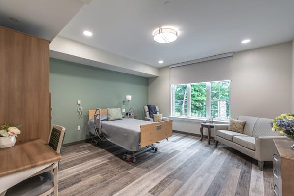 A cozy resident room with a bed and seating area