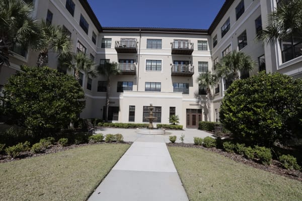 Outdoor courtyard with fountain and surrounding greenery