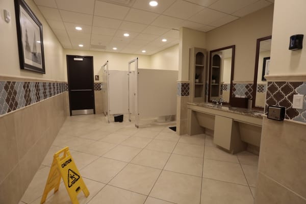 Interior view of bathroom with stalls and sinks