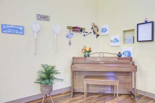 Decorative corner with piano and fishing theme decor