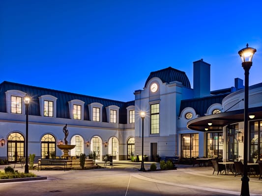 Exterior view of a senior facility with garden at dusk
