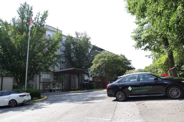 Exterior view of Abe's Garden Community with cars in parking lot