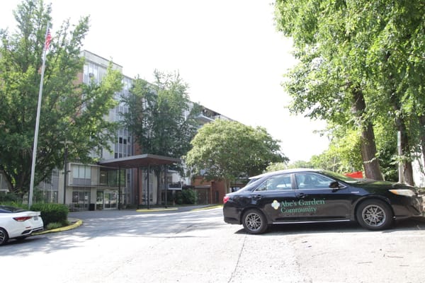 Exterior view of Abe’s Garden Community with facility logo on vehicle
