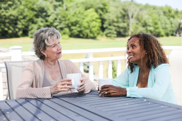 Two women enjoying drinks on an outdoor patio