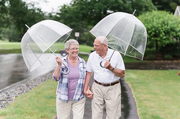 Two residents walking together under umbrellas