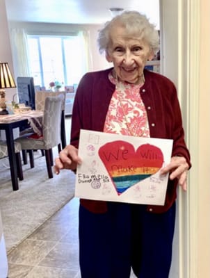 Resident holding a colorful sign with a positive message