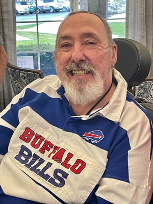 Smiling resident in a blue shirt in a common area