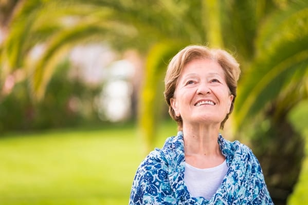 Smiling resident outdoors with palm trees in the background