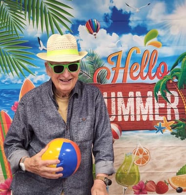 Resident enjoying a summer-themed photo backdrop