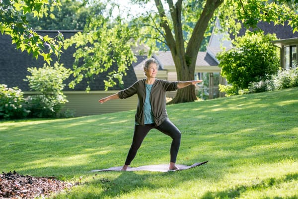 Resident practicing yoga in a sunlit outdoor space