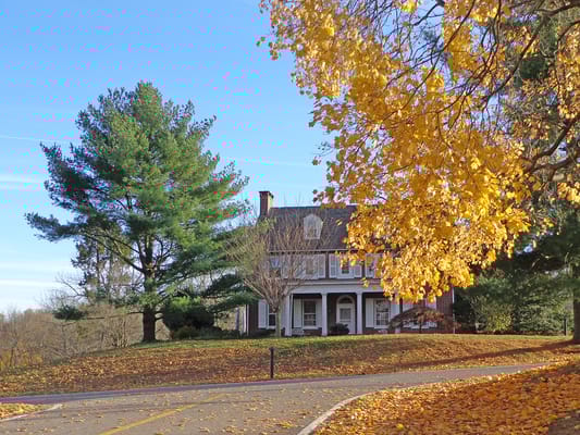 Exterior view of a senior living facility surrounded by autumn foliage