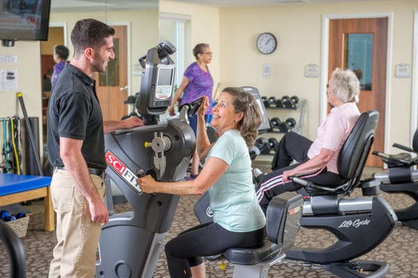Residents exercising in a bright fitness room