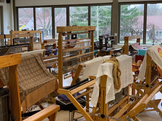 Weaving area filled with looms and fabric