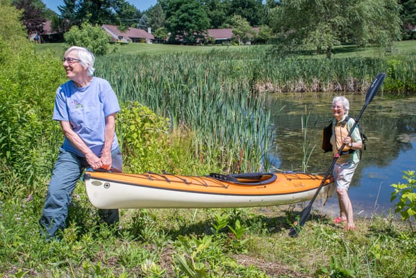 Residents engaging in kayaking by a pond