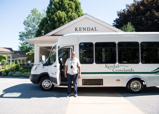 Transit bus parked outside the Kendal facility with staff member