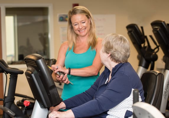 Staff assisting a resident in a fitness room