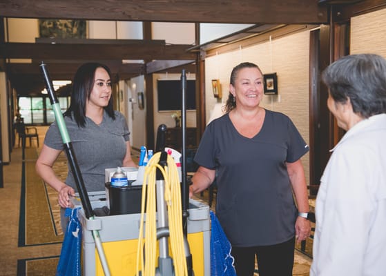 Staff members interacting in a hallway with cleaning equipment