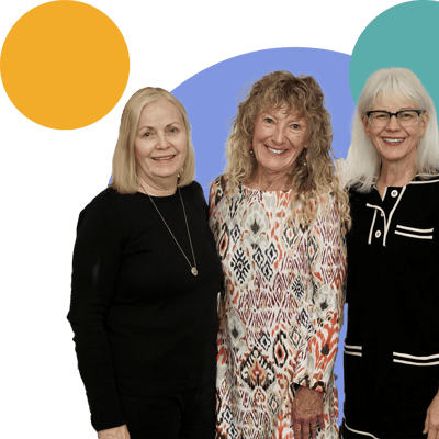 Three staff members smiling in a colorful background