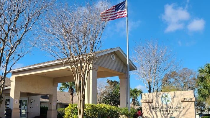 Front entrance of Magnolia Gardens Assisted Living with American flag