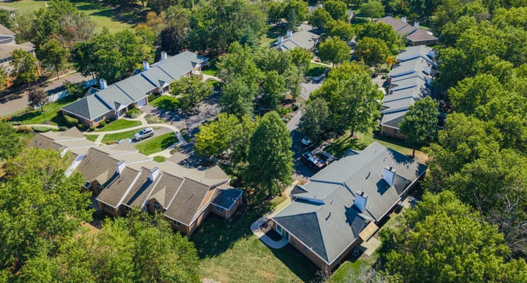 Aerial view of a senior living campus with trees and pathways