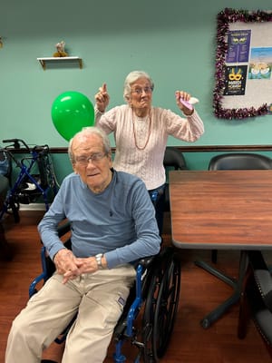 Two engaged seniors participating in an activity indoors