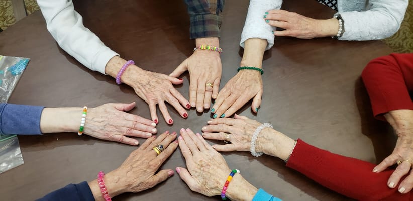 Close-up of hands with colorful bracelets in a circle