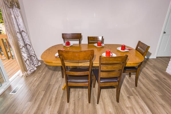 Dining area with wooden table and chairs set for a meal