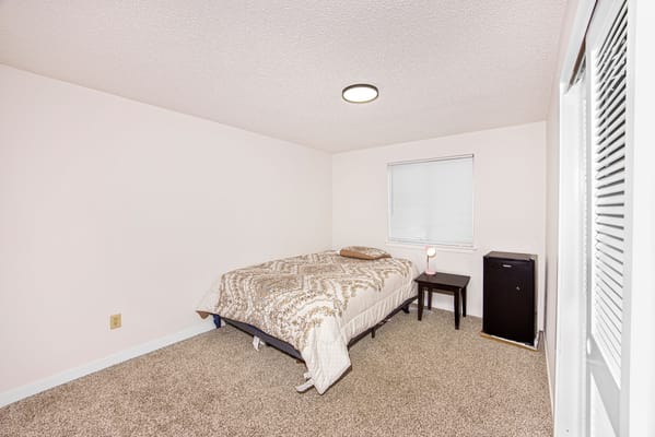 A private resident room with a bed and small fridge