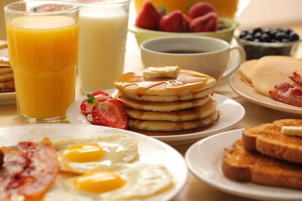 A breakfast spread featuring pancakes, eggs, and fruit