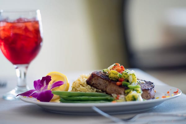 Plated meal with fish, vegetables, and a drink