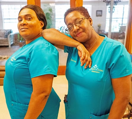 Two staff members posing in their uniforms in a common area