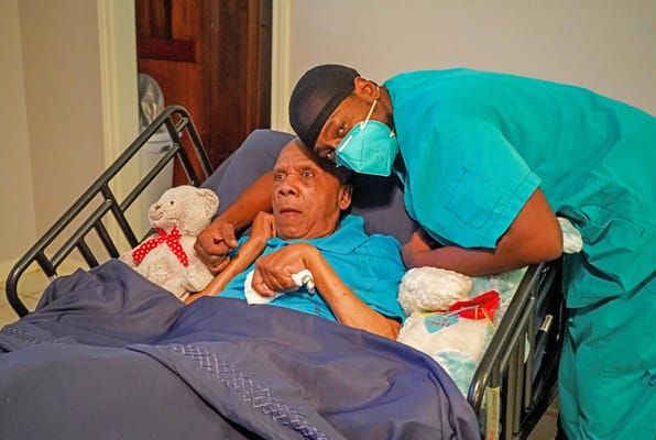 Staff member assisting a resident in a care room