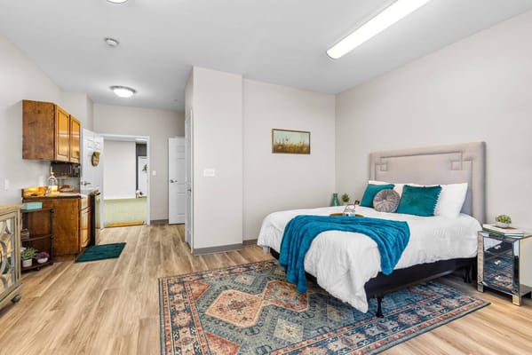 Cozy interior of a resident room with a bed and kitchenette