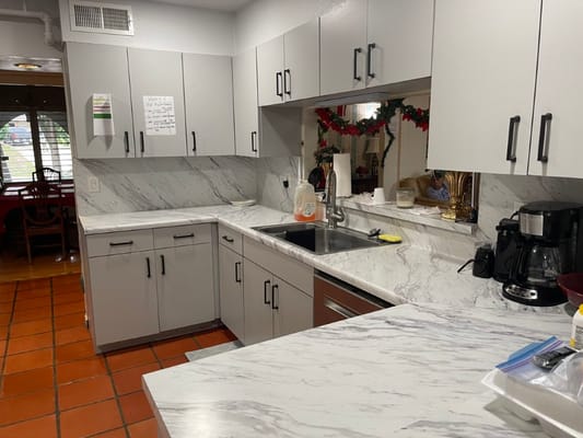 Bright kitchen area with marble countertops and appliances