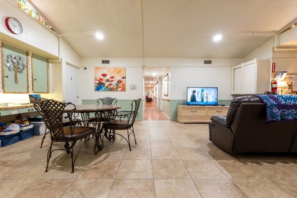 Common area with tables and a TV in the facility