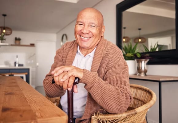 Smiling senior man seated at a table in a cozy environment