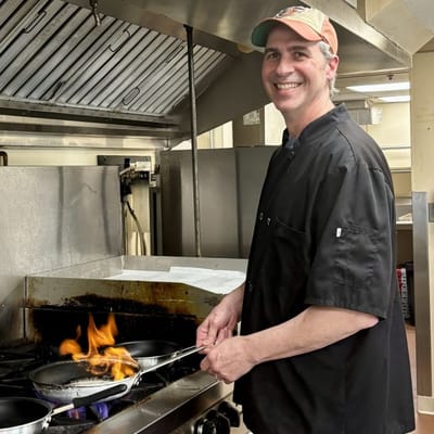 Chef cooking with flames in a kitchen