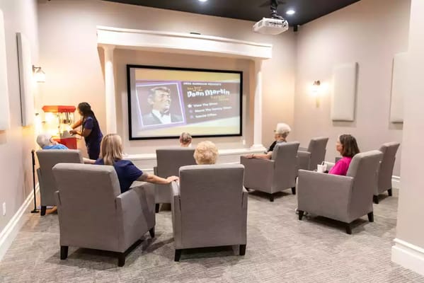 Residents watching a movie in a cozy theater room