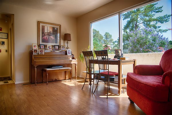 Bright interior living space with a piano and dining area